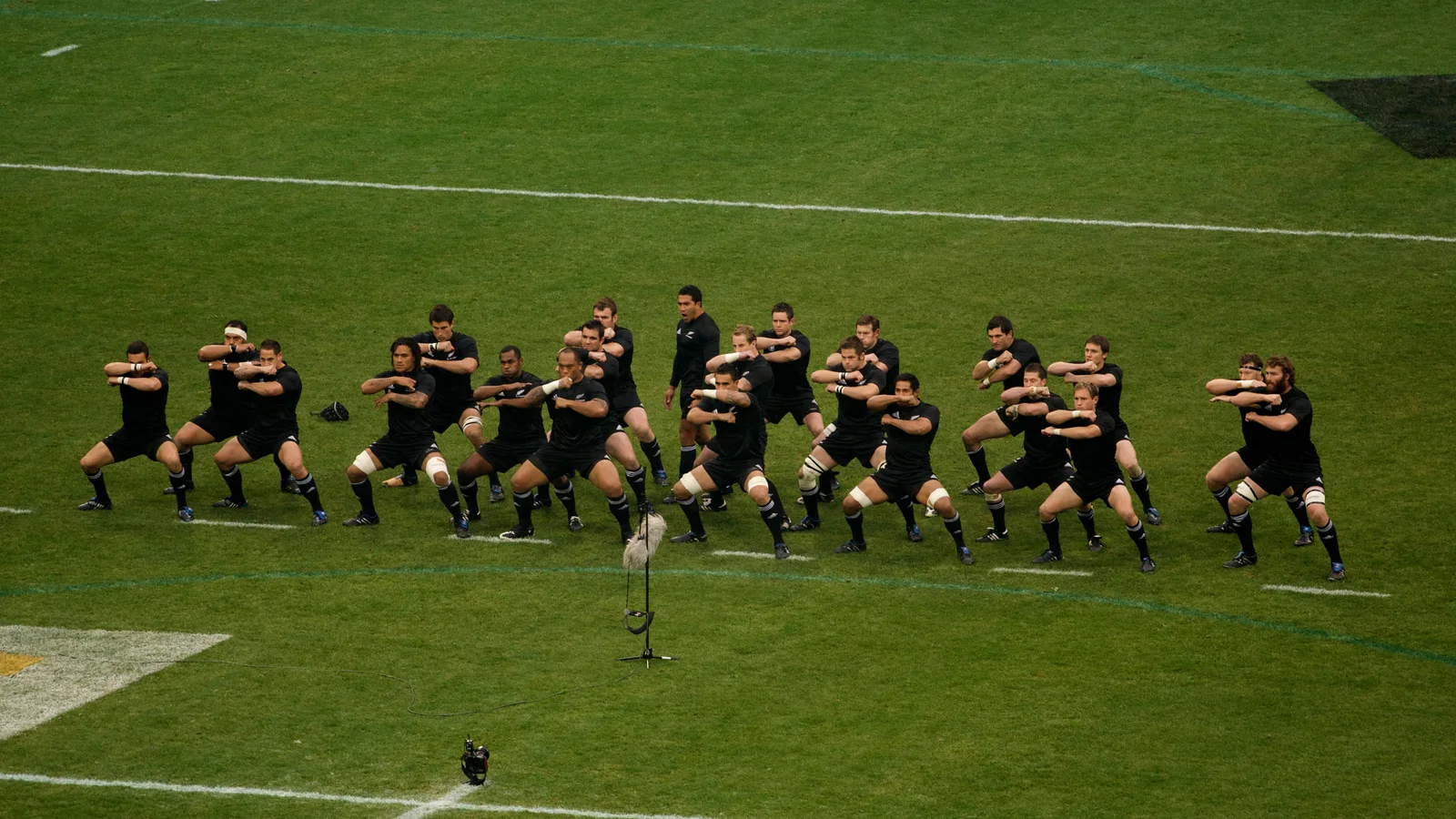 Jogadores dos All Blacks alinhados no gramado durante o haka, em Milão, em 2009.