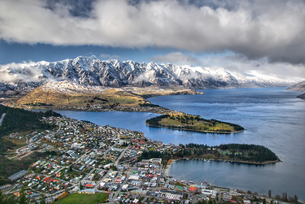 Vista elevada de Queenstown, das águas azuis do lago Wakatipu e das montanhas cobertas de neve.