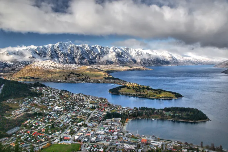 Vista elevada de Queenstown, das águas azuis do lago Wakatipu e das montanhas cobertas de neve.